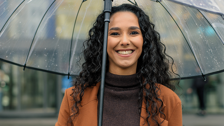 Woman smiling in the rain in [acf field=city post_id=options] and [test_shortcode]